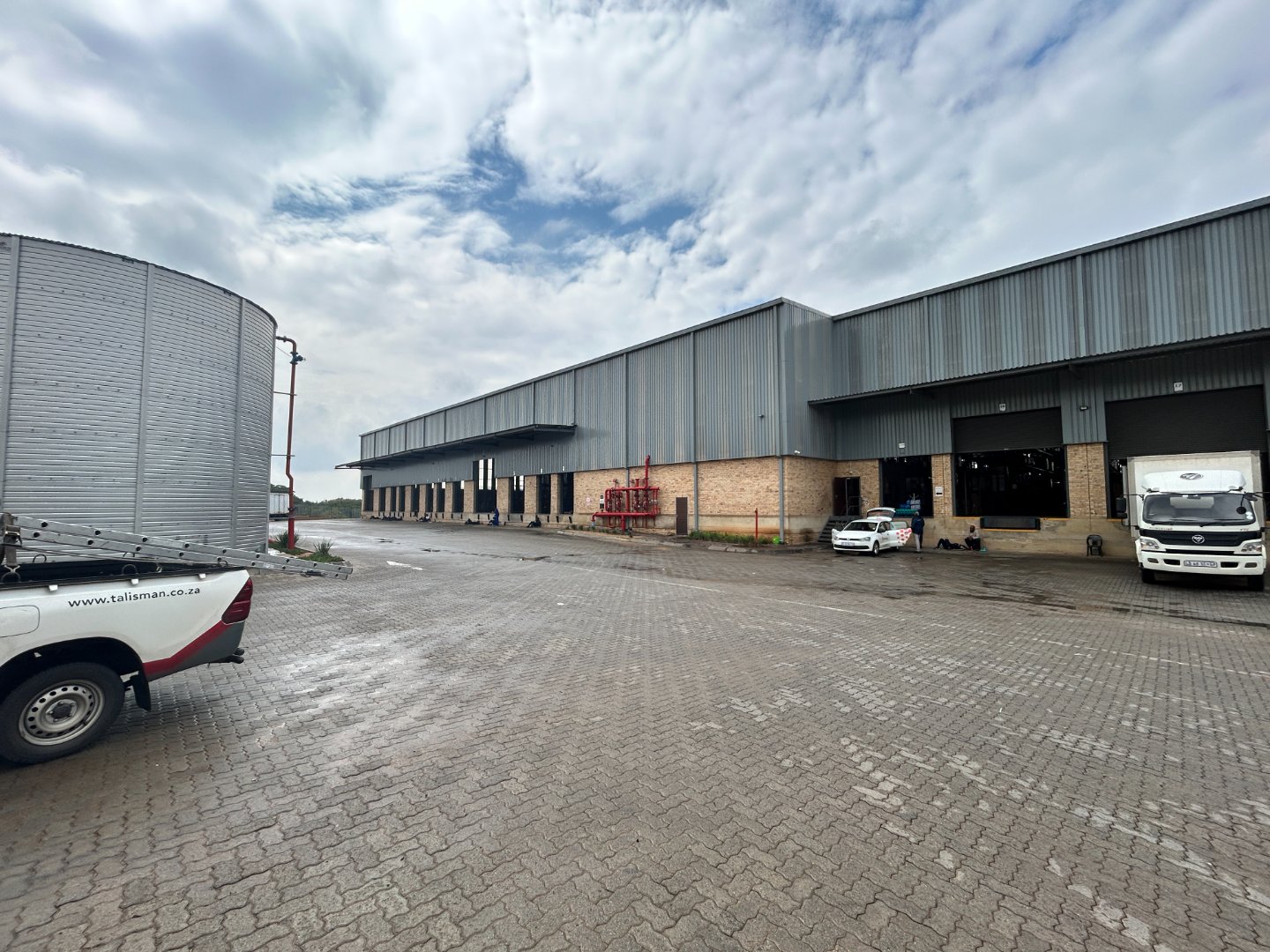 Currie Group Offices and Warehouses Modern industrial offices and warehouses of Currie Group, established since 1887, featuring large storage facilities and company vehicles on-site.