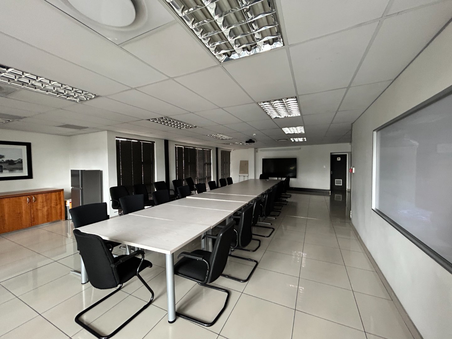 Conference room with a large table and black chairs in a professional office setting.