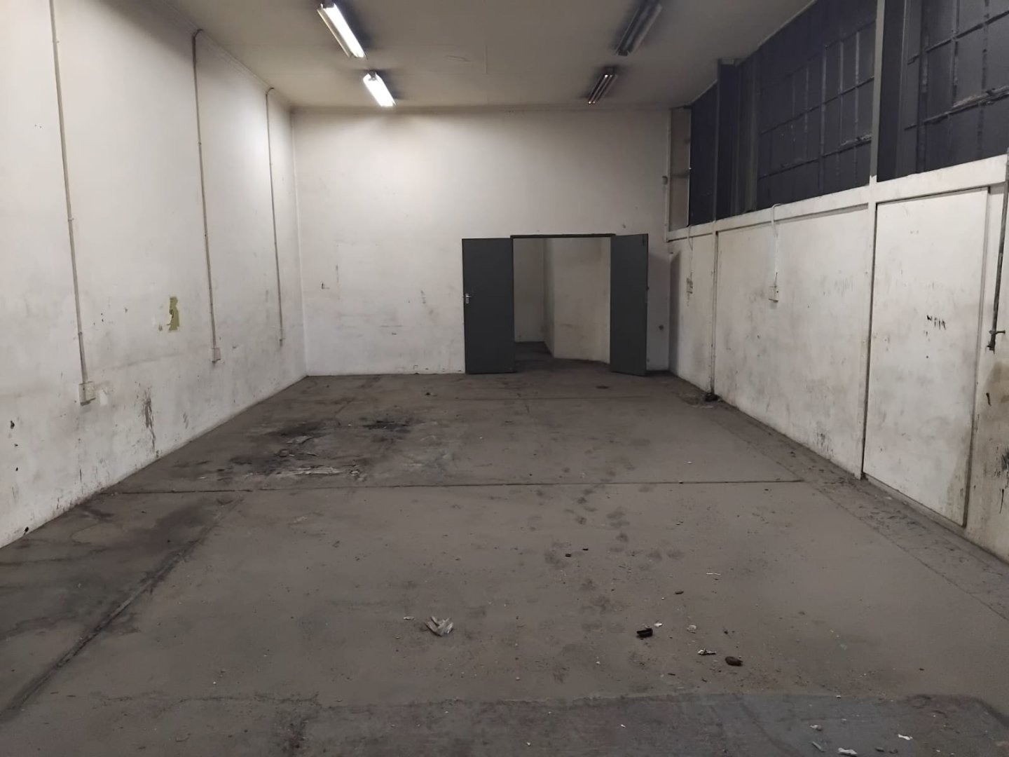 Warehouse space at Currie Group offices and warehouses. Empty warehouse space with white walls and concrete floor at Currie Group offices and warehouses.