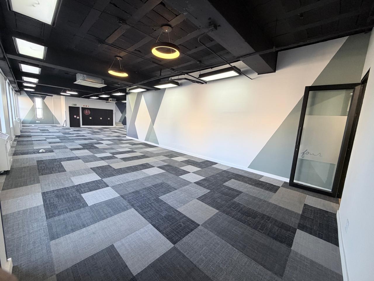 Office interior with contemporary design, geometric wall accents, and modern lighting, showcasing a professional workspace environment.