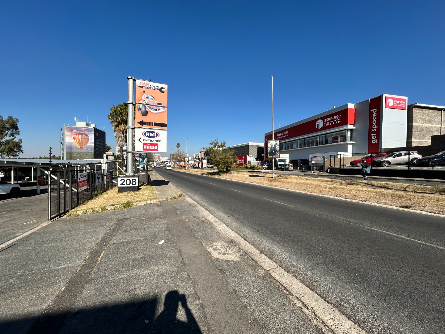 Wide view of a commercial dealership and warehouse complex in Randburg with clear blue sky and signage for automotive and retail businesses.