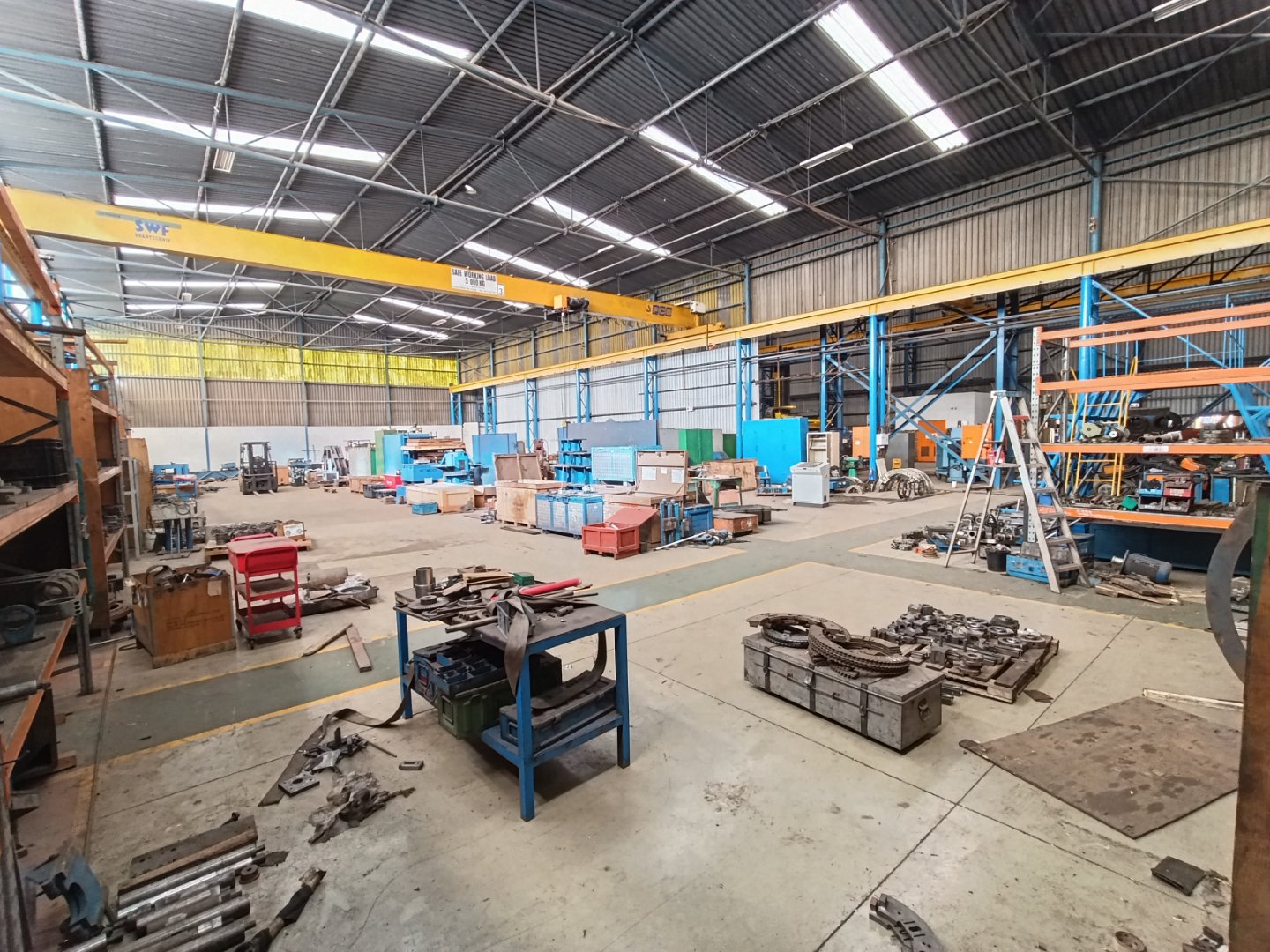 Currie Group Warehouse Facility Interior view of Currie Group's industrial warehouse showing equipment, storage racks, and workstations in a spacious, well-lit environment.