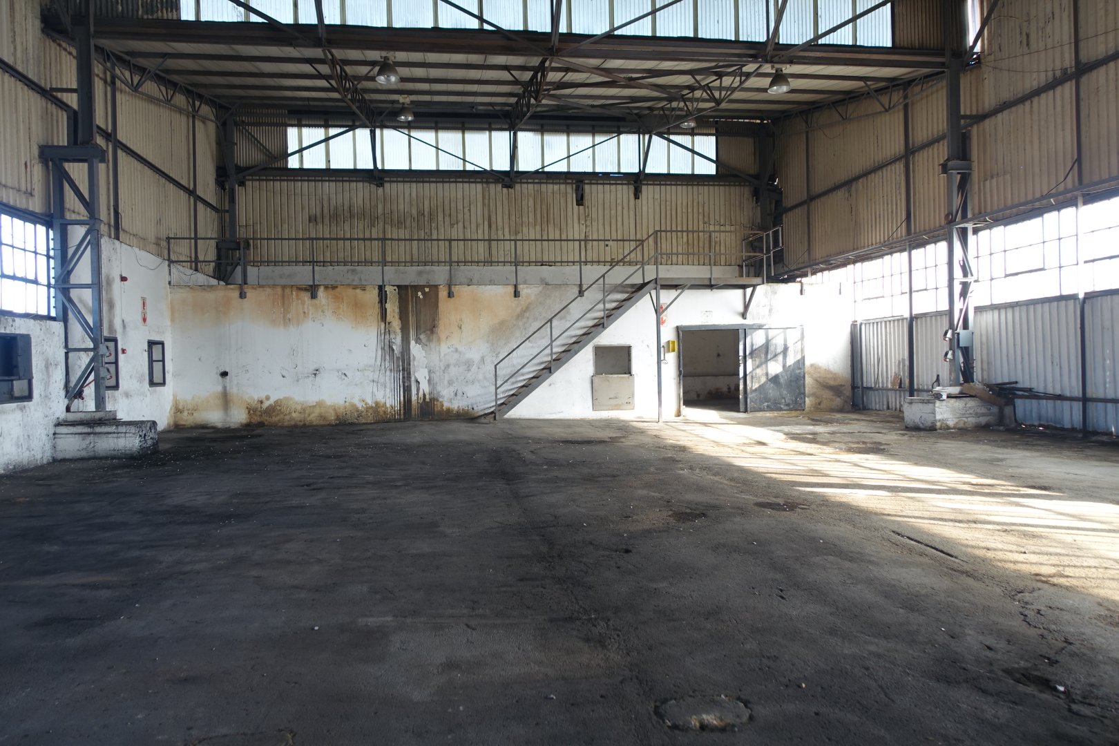 Spacious Warehouse Interior for Storage Large industrial warehouse with high ceilings, metal framework, and concrete floor, suitable for storage and logistics operations.