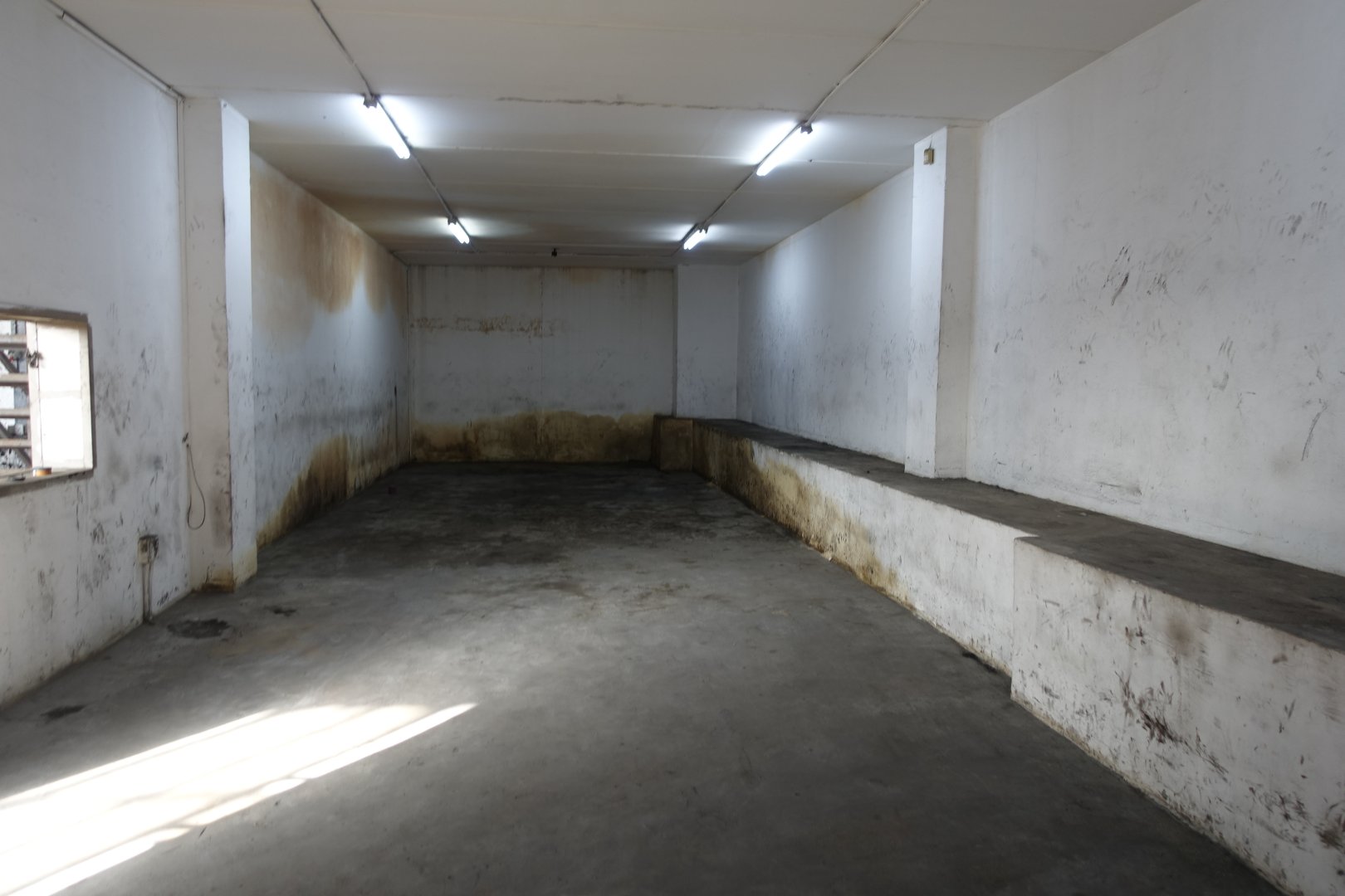 Industrial Warehouse Space for Storage Empty industrial warehouse with concrete floors and white walls, suitable for storage or manufacturing.