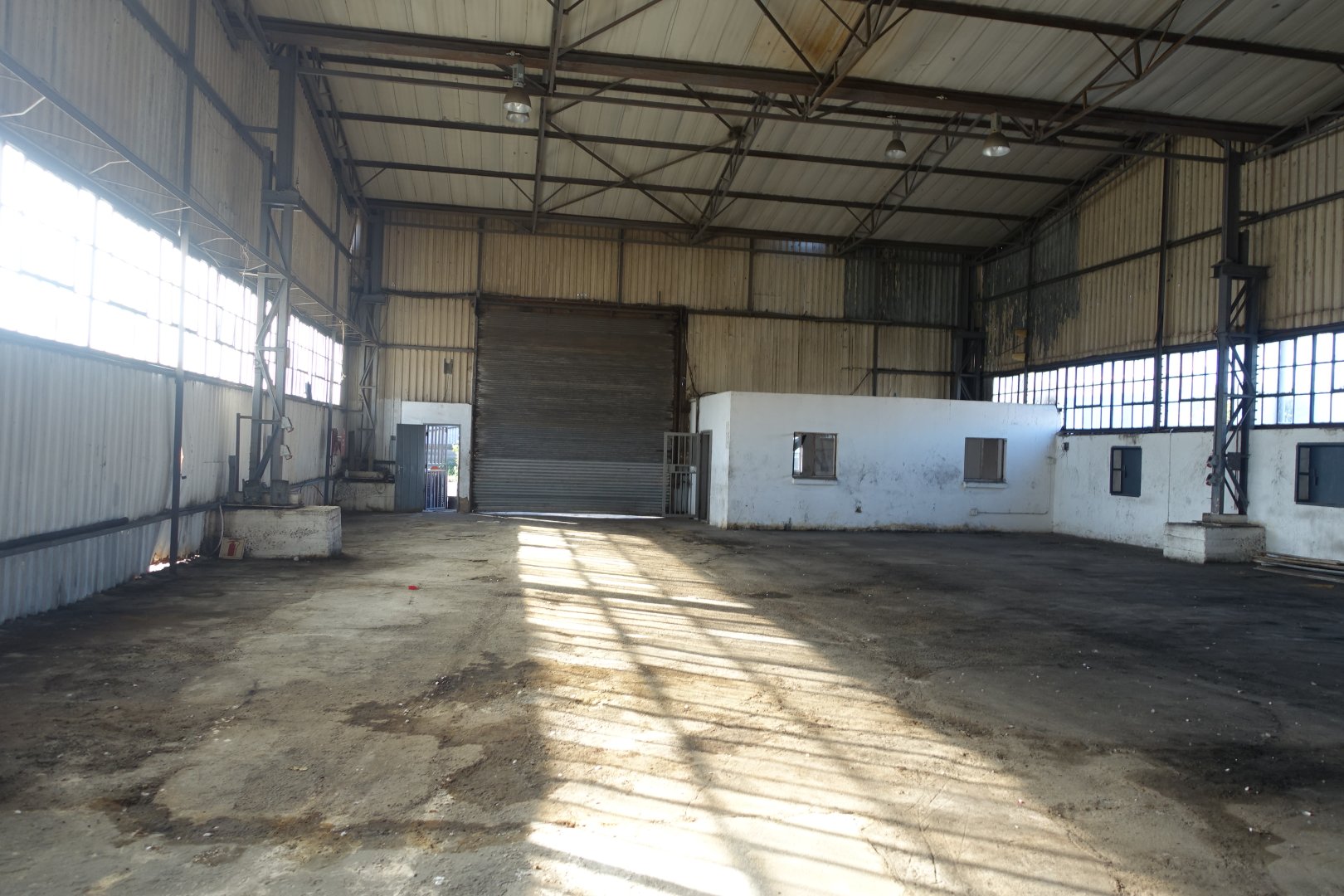 Old Warehouse Interior at Currie Group Spacious warehouse interior with high ceilings, large windows, and a concrete floor, showcasing the historic industrial space at Currie Group since 1887.