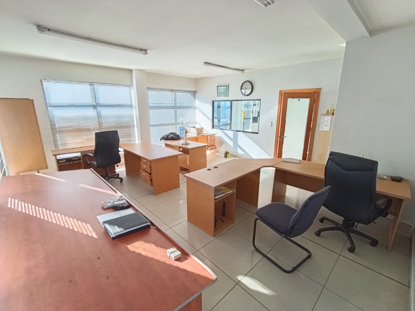 Office and Warehouse Interior Spacious office with multiple desks, chairs, and large windows providing natural light, part of Currie Group's office and warehouse facilities.