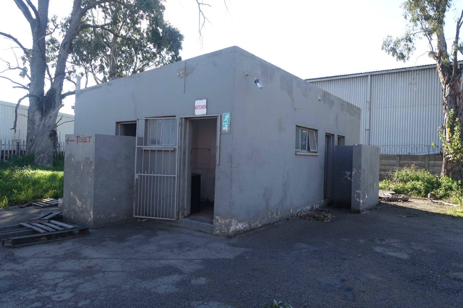 Old Warehouse at Currie Group Exterior view of an old warehouse building with a gated entrance, located at Currie Group, showcasing industrial architecture and storage facilities.