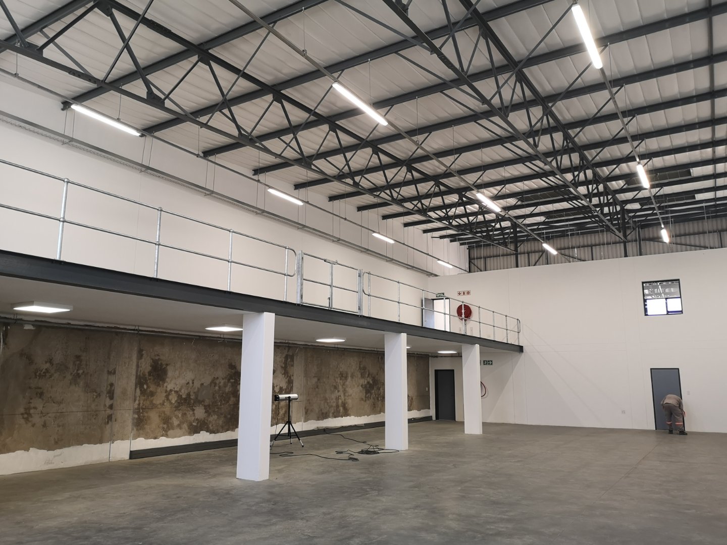 Modern Warehouse Interior at Currie Group Spacious warehouse with high ceilings, metal roof structure, and mezzanine level at Currie Group offices and warehouses.