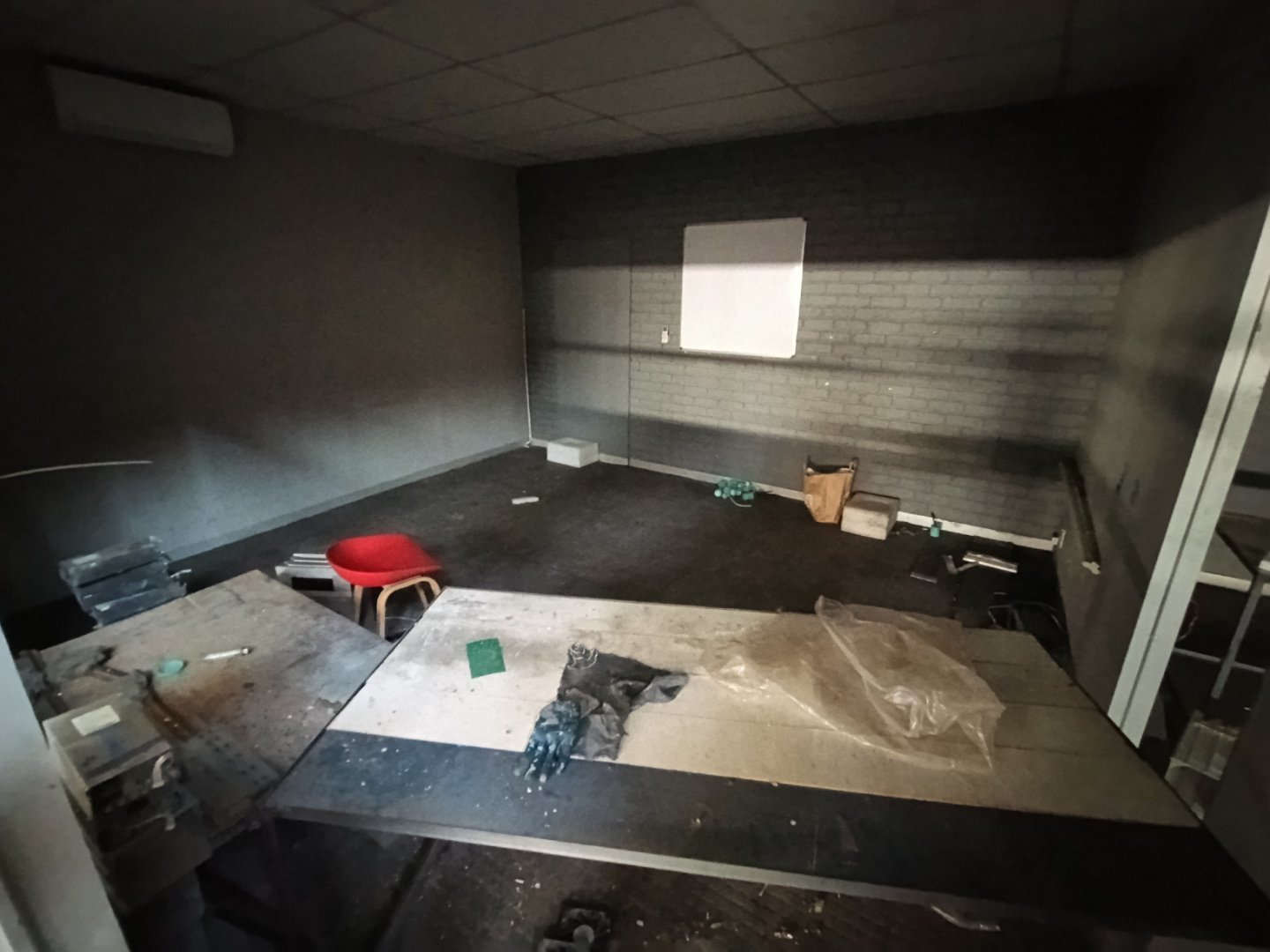 Industrial Warehouse Office Space Empty office space inside an industrial warehouse with a desk, chair, and scattered items, located in Alrode.