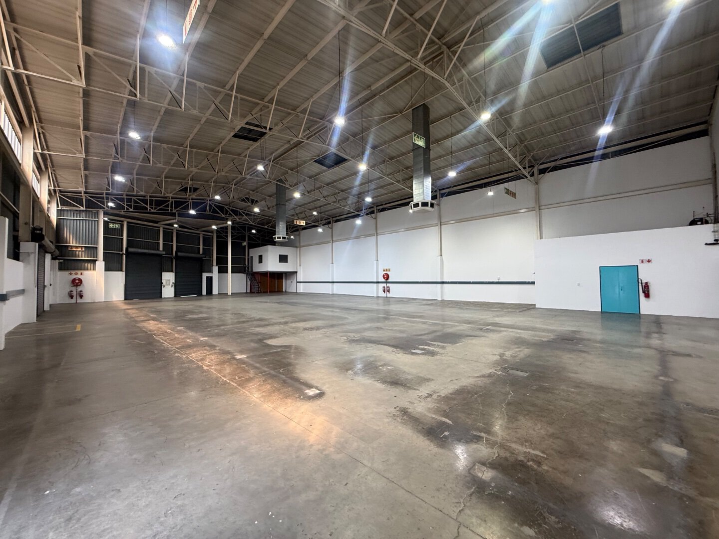 Spacious Commercial Warehouse Interior Interior view of a large, empty commercial warehouse with high ceilings, bright lighting, and polished concrete floors in Bryanston.