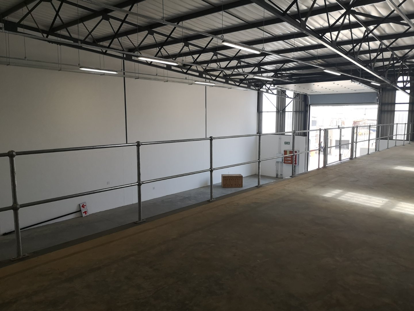 Currie Group Warehouse Interior Spacious warehouse interior with high ceilings, metal roof structure, and safety railings, part of Currie Group's office and warehouse facilities.
