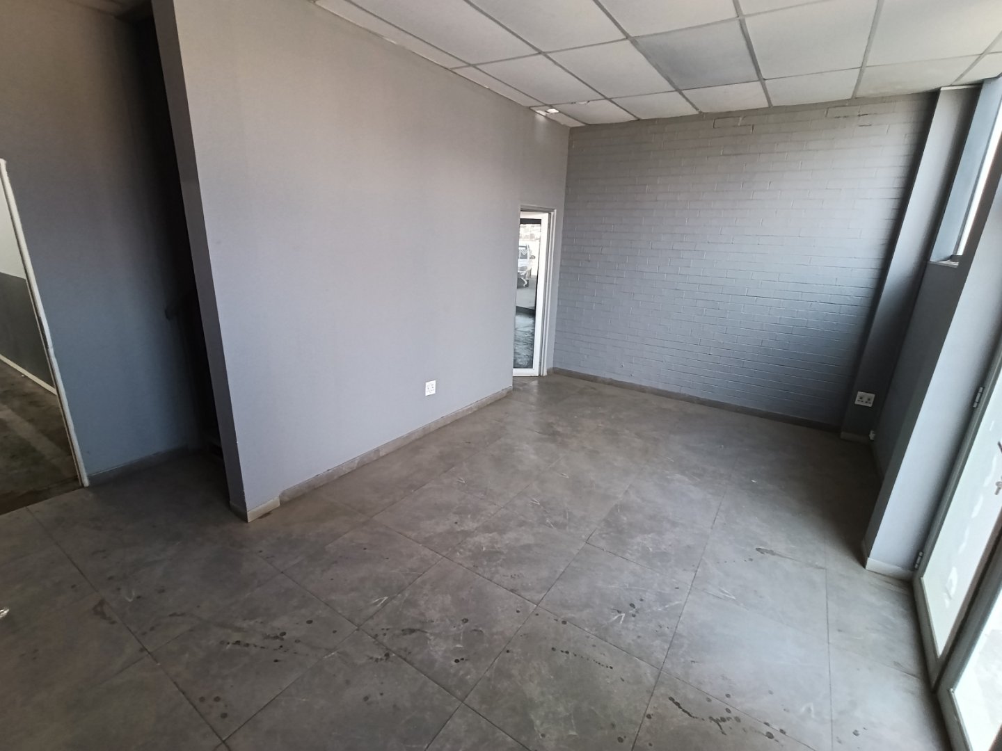 Modern Office Space in Alrode Spacious, empty office room with large windows and concrete flooring in Alrode industrial warehouse.