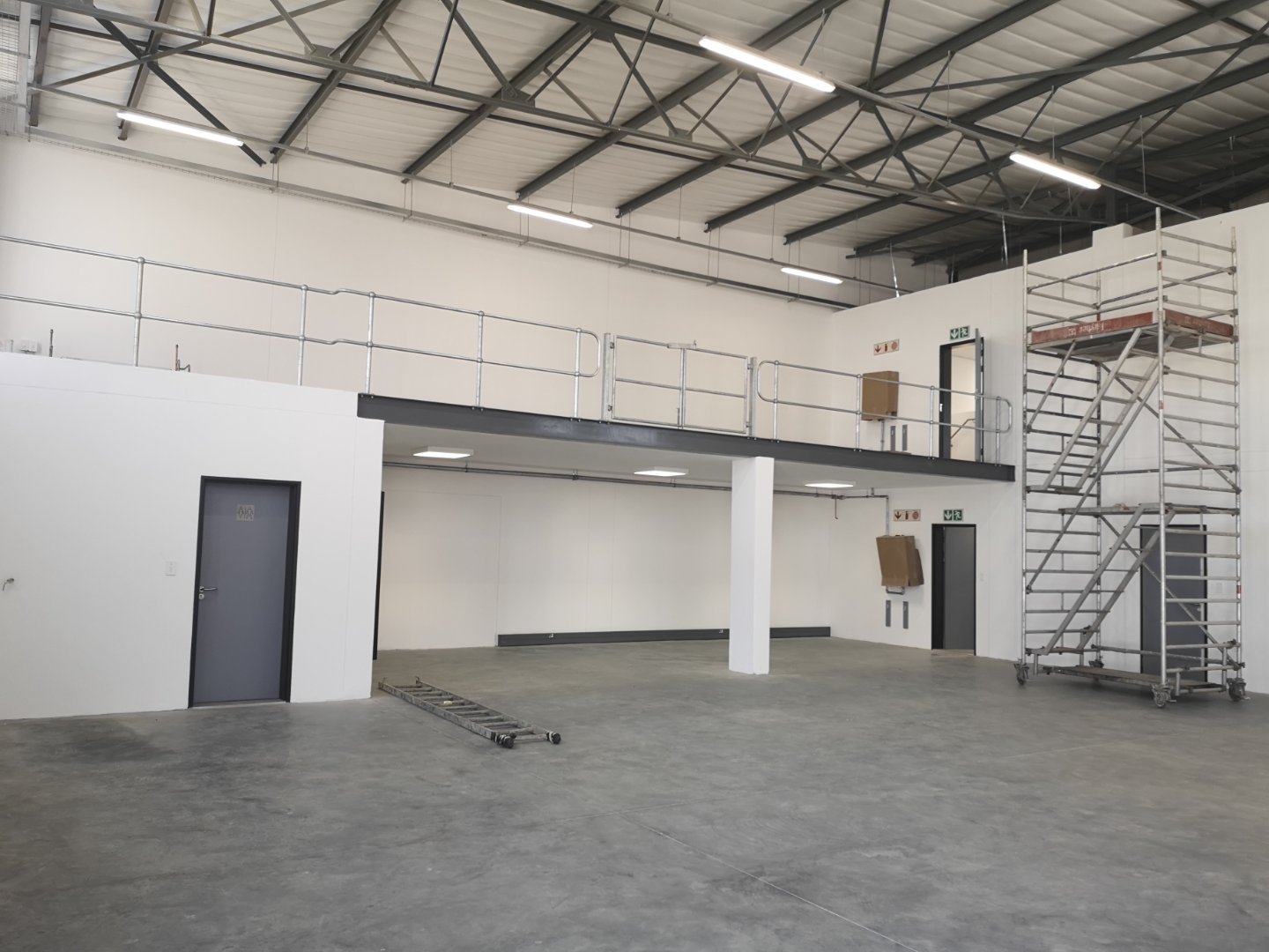 Spacious interior of Currie Group offices and warehouses with high ceilings, scaffolding, and modern industrial design since 1887.