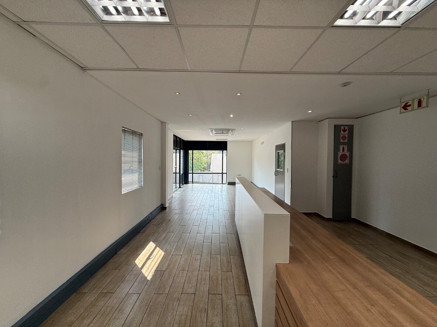 Modern Office Interior at Currie Group Spacious office interior with wooden flooring, white walls, and large windows providing natural light at Currie Group offices.