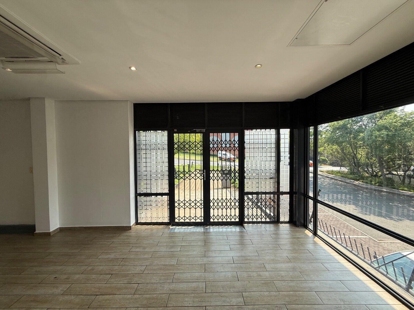 Modern Office Space in Bryanston Spacious office interior with large glass windows and wooden flooring, showcasing a professional workspace in Bryanston.