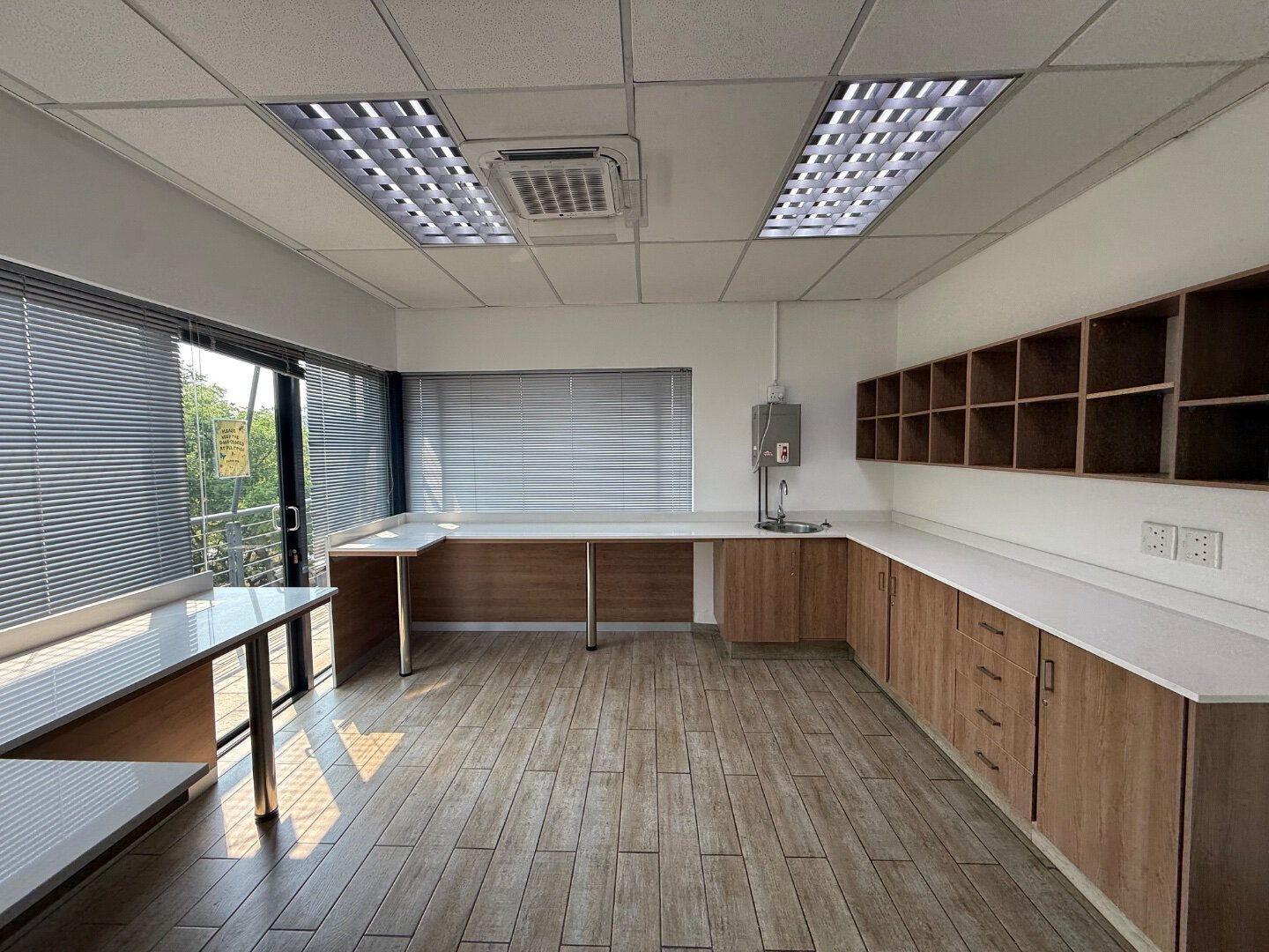 Modern Office Space in Bryanston Spacious office room with large windows, wooden cabinets, and ample natural light, suitable for business operations in Bryanston.