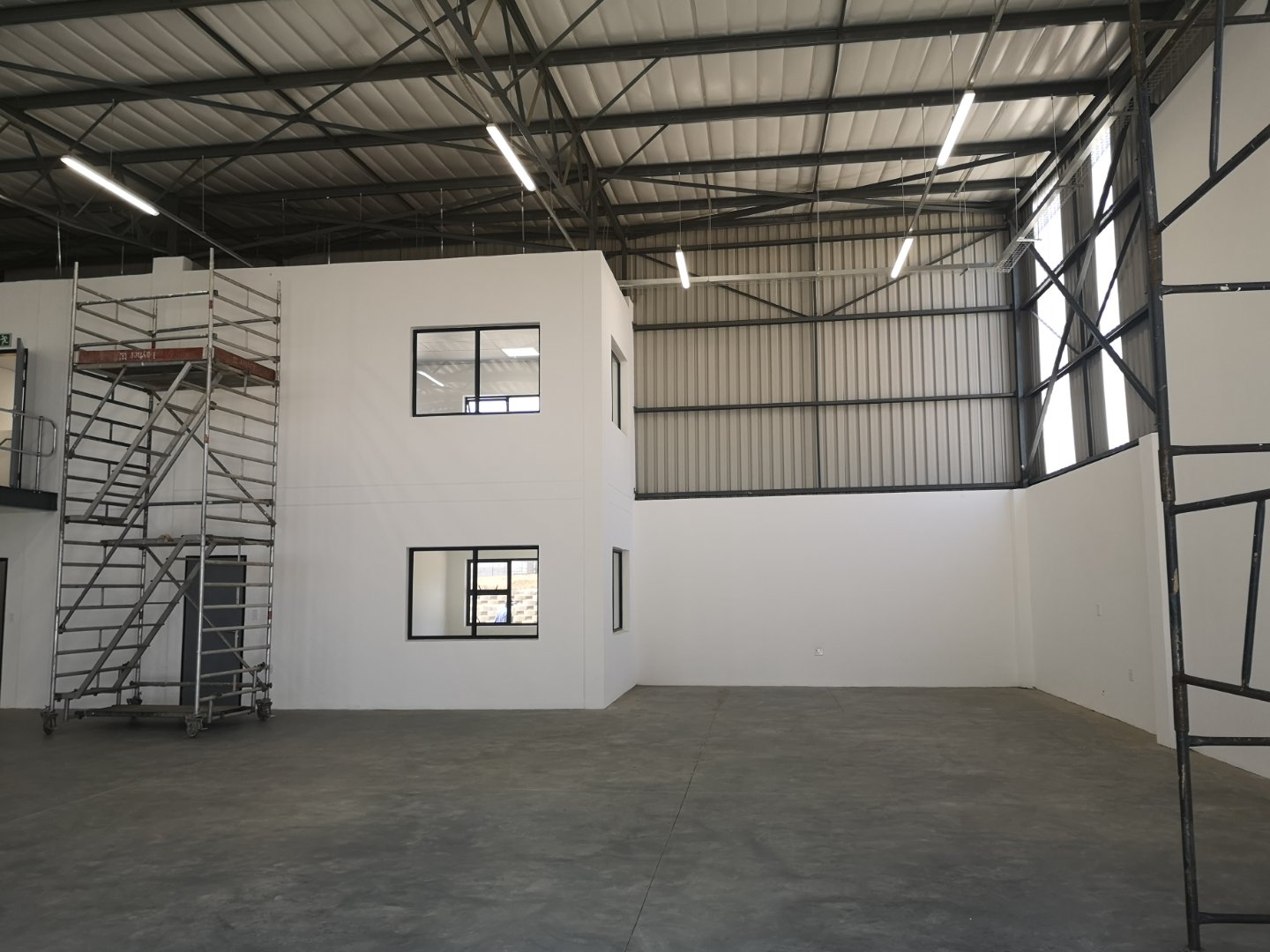 Interior view of a modern office and warehouse facility with white walls, high ceilings, and large windows, showcasing Currie Group's industrial infrastructure.