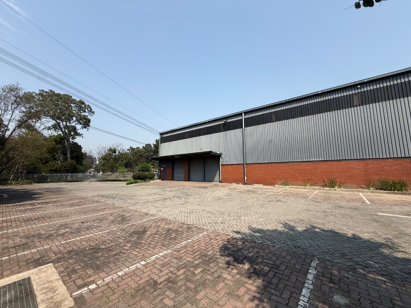Modern Warehouse in Bryanston Spacious industrial warehouse with parking lot in Bryanston, showcasing modern commercial building design and ample outdoor space.