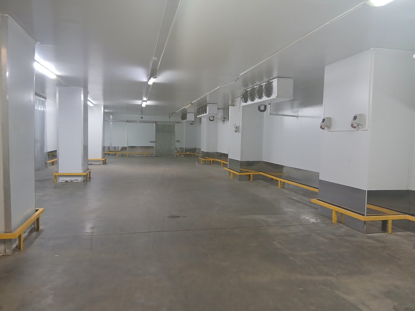 Modern Office Warehouse Space Spacious, clean office warehouse with white walls, concrete floors, and ventilation systems, designed for efficient storage and operations.