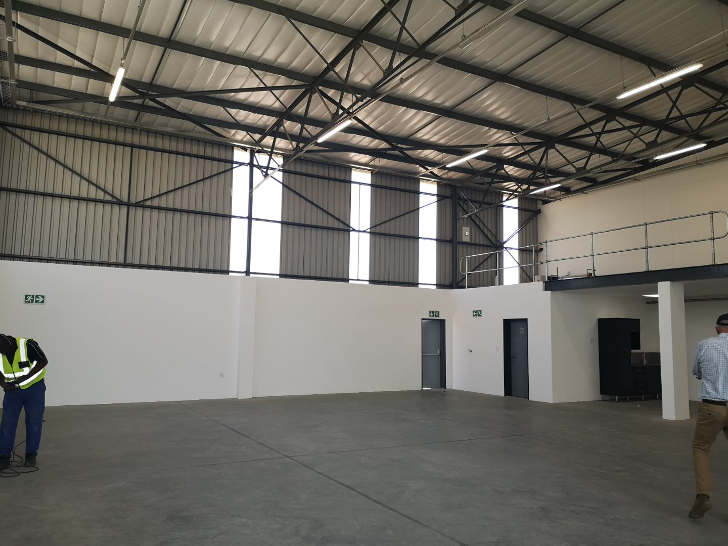 Currie Group Warehouse Interior Spacious warehouse interior of Currie Group with high ceilings, metal roof, and minimal equipment, showcasing modern office and storage facilities.