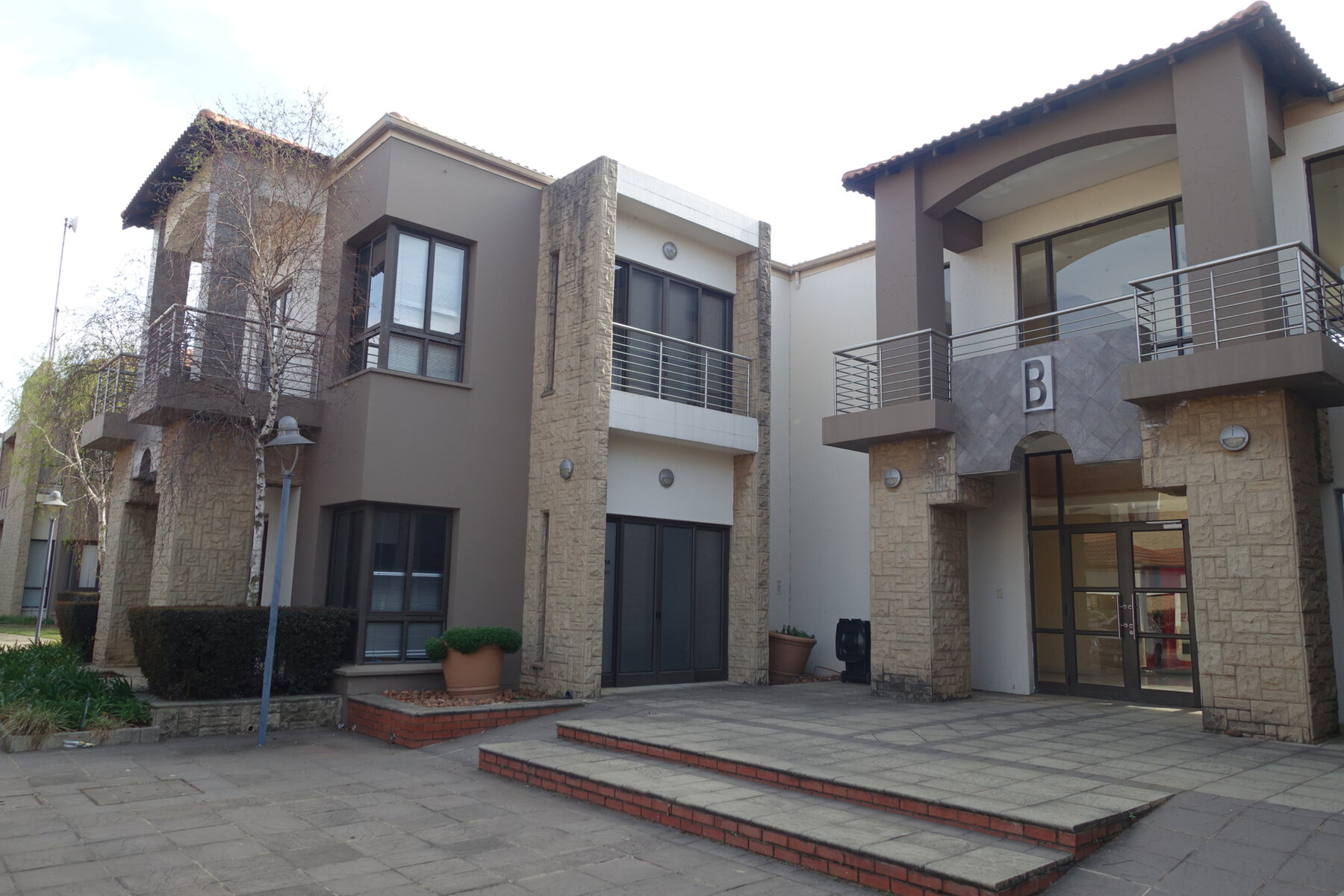 Contemporary office building with modern architecture, large windows, and balconies at Clear Water Office Park, showcasing professional commercial property design.