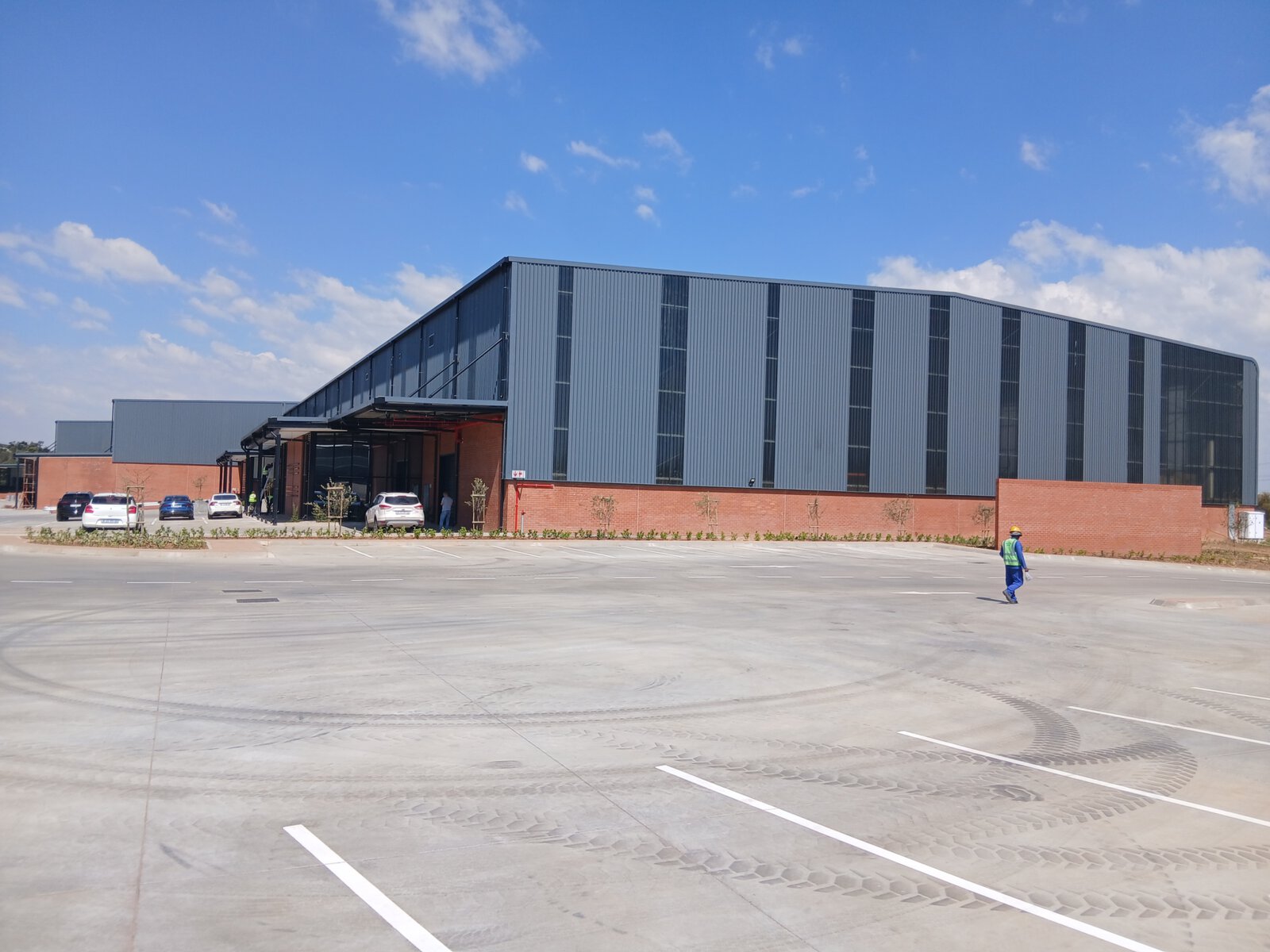 Spacious modern warehouse with parking area and clear sky at Currie Group offices and warehouses since 1887.
